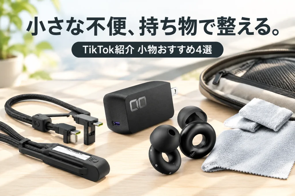 明るい机の上の開いたガジェットポーチ。黒い短い充電ケーブル、コンパクトなUSB-C充電器、リング形の耳栓とケース、グレーのクロスを大きく並べた外出準備のイメージ。