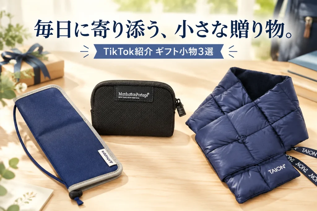 明るい木目の机と通学バッグが少し見える上品なギフト風景。ネイビーとグレーのペンケース、黒タグの黒いコインケース、ネイビーのダウンマフラーを各1点ずつ大きく。